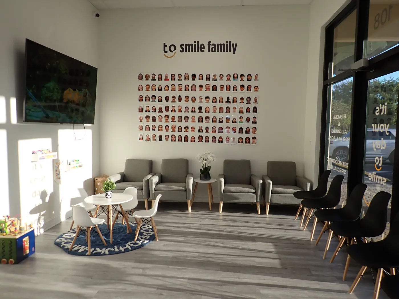 Bright Miami Lakes waiting room with the 'to smile family' wall and front entrance