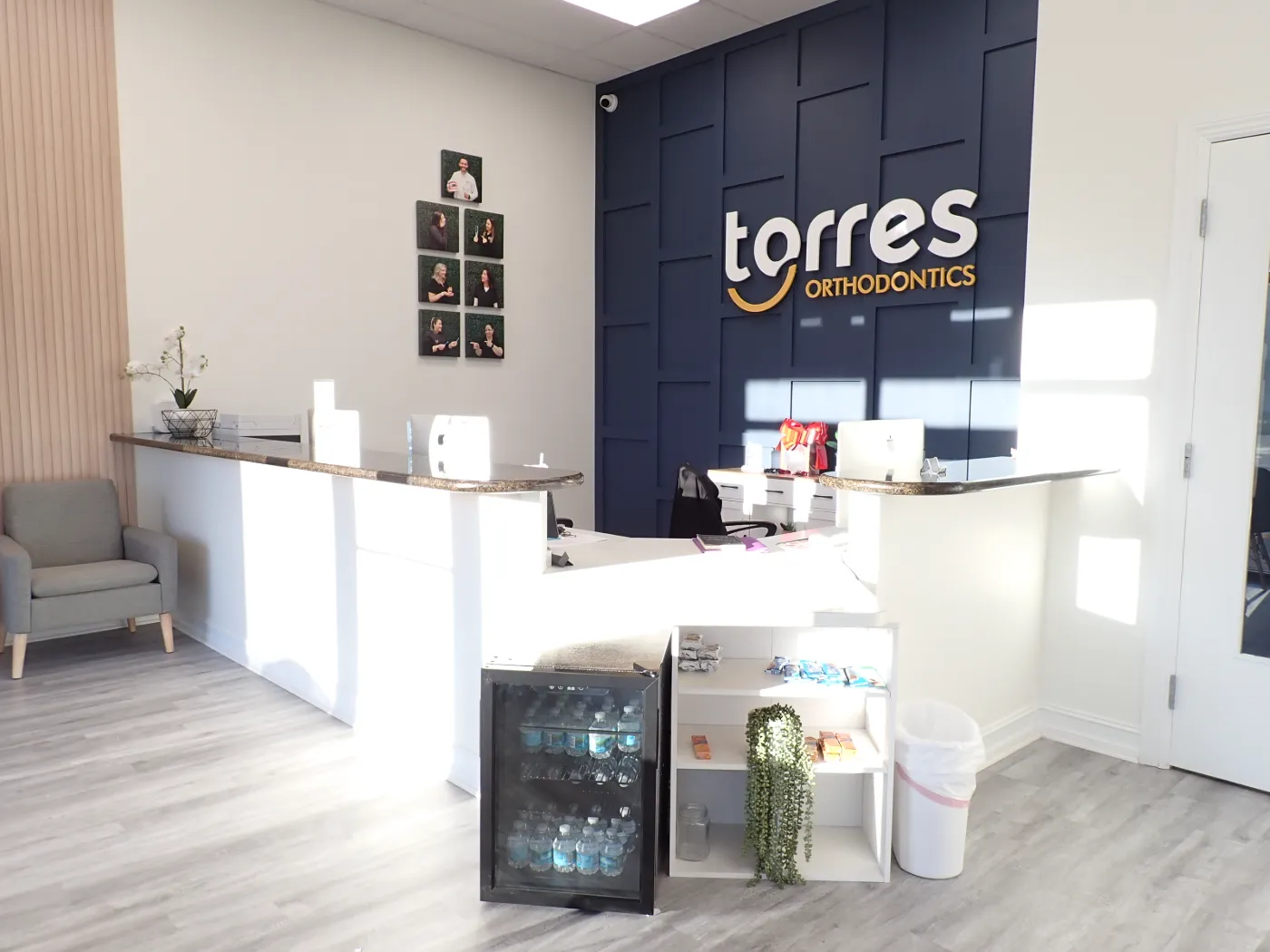 Torres Orthodontics Miami Lakes reception desk and navy branded logo wall