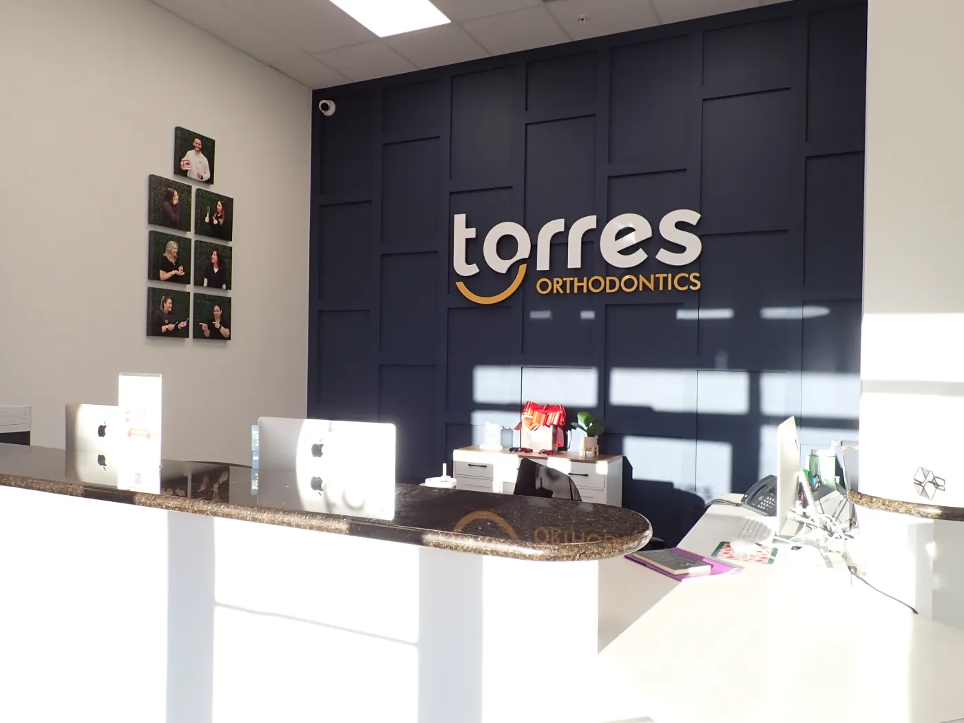 Front desk and torres ORTHODONTICS logo wall at the Miami Lakes office